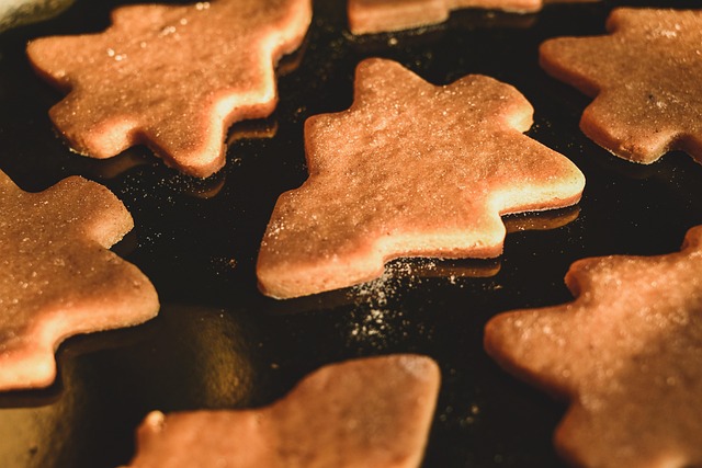 검은색 오븐 팬 위에 구워진 트리 모양의 쿠키